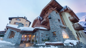 A multi-story hotel with stone and wooden architecture, featuring balconies and a stone entrance. - Maison Saint Jean (Courmayeur)