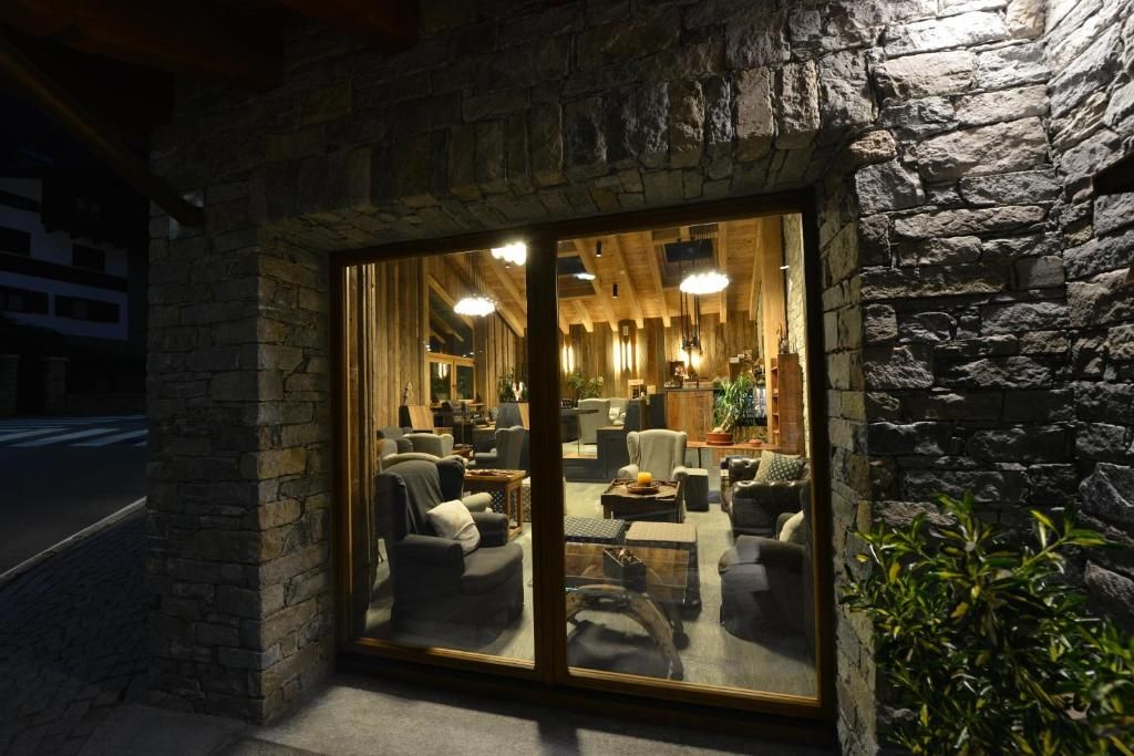 A cozy interior with a stone facade, wooden ceiling beams, and comfortable seating.