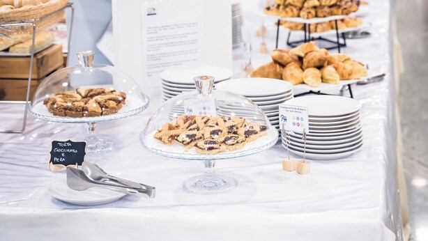Una mesa de buffet con diversos alimentos y un cartel que indica una sección sin gluten.