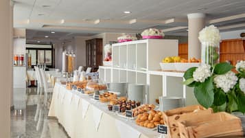 Un bufé con diferentes opciones de comida y una unidad blanca de estanterías al fondo.