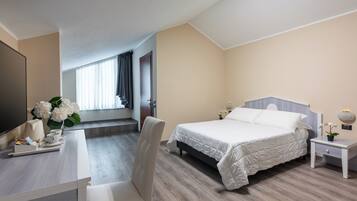 Une chambre d’hôtel avec un lit, un bureau et une télévision.