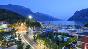 A marina with boats, a swimming pool, and a road with vehicles. - Riviera (Riva del Garda)