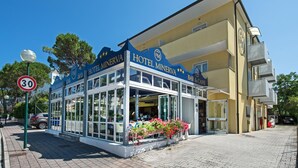 A two-story building with a blue facade and a sign reading "Hotel Minerva". - Hotel Minerva (Lignano Sabbiadoro)