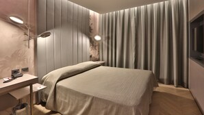 A modern hotel room with a bed, bedside table, lamp, and curtains. - Palace Hotel Moderno (Pordenone)