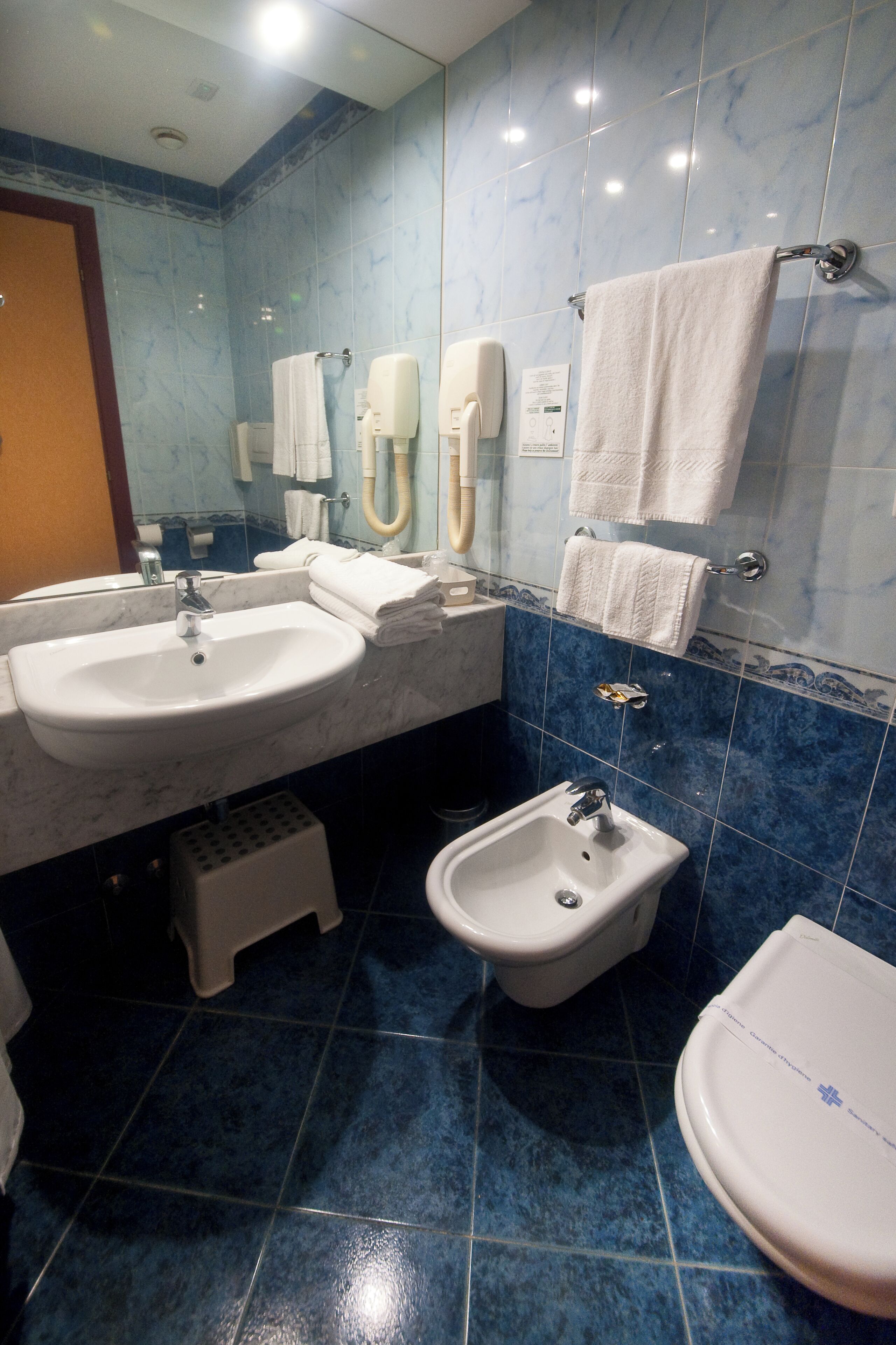 Une salle de bain avec deux lavabos, un bidet et des toilettes.