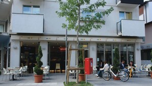 Un edificio con terraza y una bicicleta estacionada adelante.