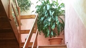 A wooden staircase with a metal railing leading to a landing. - Hotel Chopin (Milan)