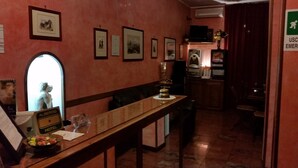 A hotel lobby with framed pictures on the walls, a reception desk, and a TV mounted on the wall. - Hotel Chopin (Milan)