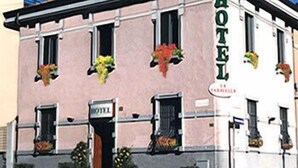 Un hotel con una facciata classica, numerose finestre e fioriere.