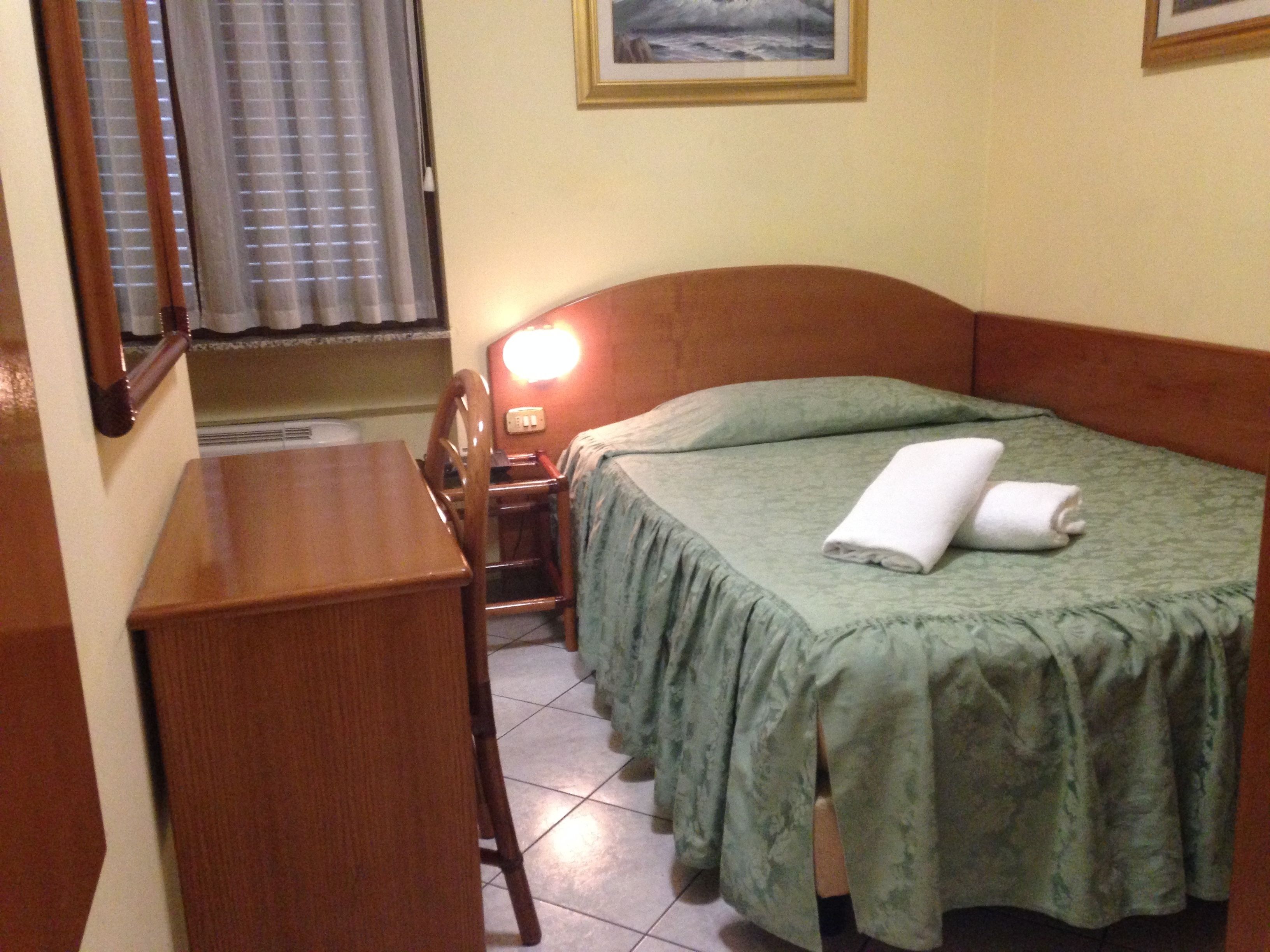 Een hotelkamer met een bed, een bureau en een stoel.