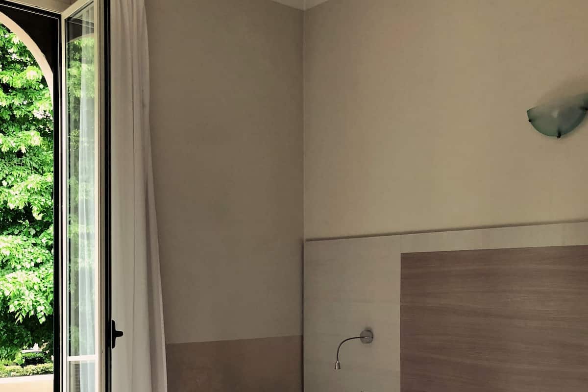Escritorio, cortinas blackout y tabla de planchar con plancha