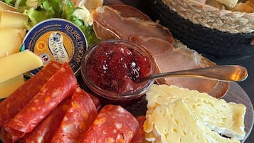 A charcuterie board with various meats, cheeses, and bread.