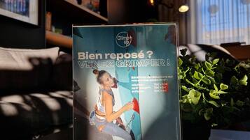Cartel promocional de Climb Up en el vestíbulo de un hotel con una mujer escalando.