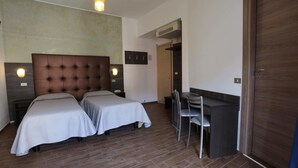 A hotel room with two beds, a desk, and a chair. - Hotel Piola (Milan)