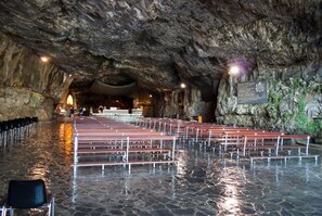 A cave-like interior with stone benches and a stone floor. - Costa (Costa Valle Imagna)