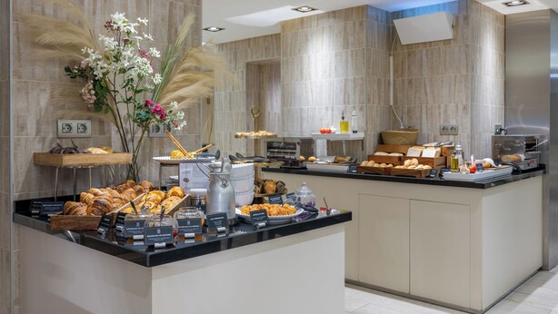 Zona de bufé con diferentes alimentos y una planta decorativa.