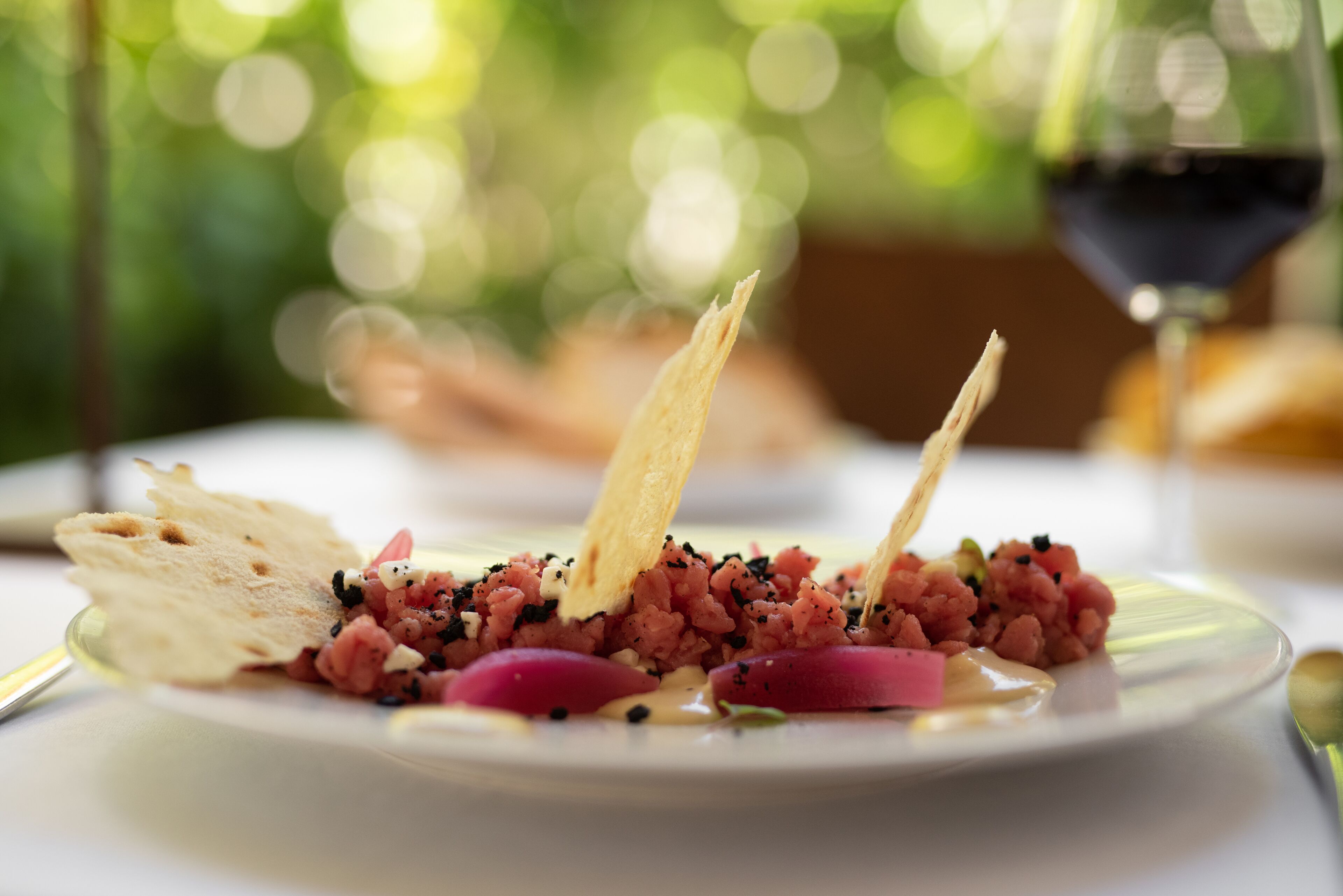A plate of food with a drink in the background.