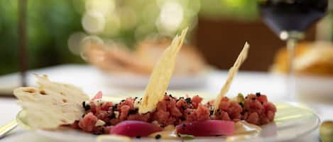 A plate of food with a drink in the background.