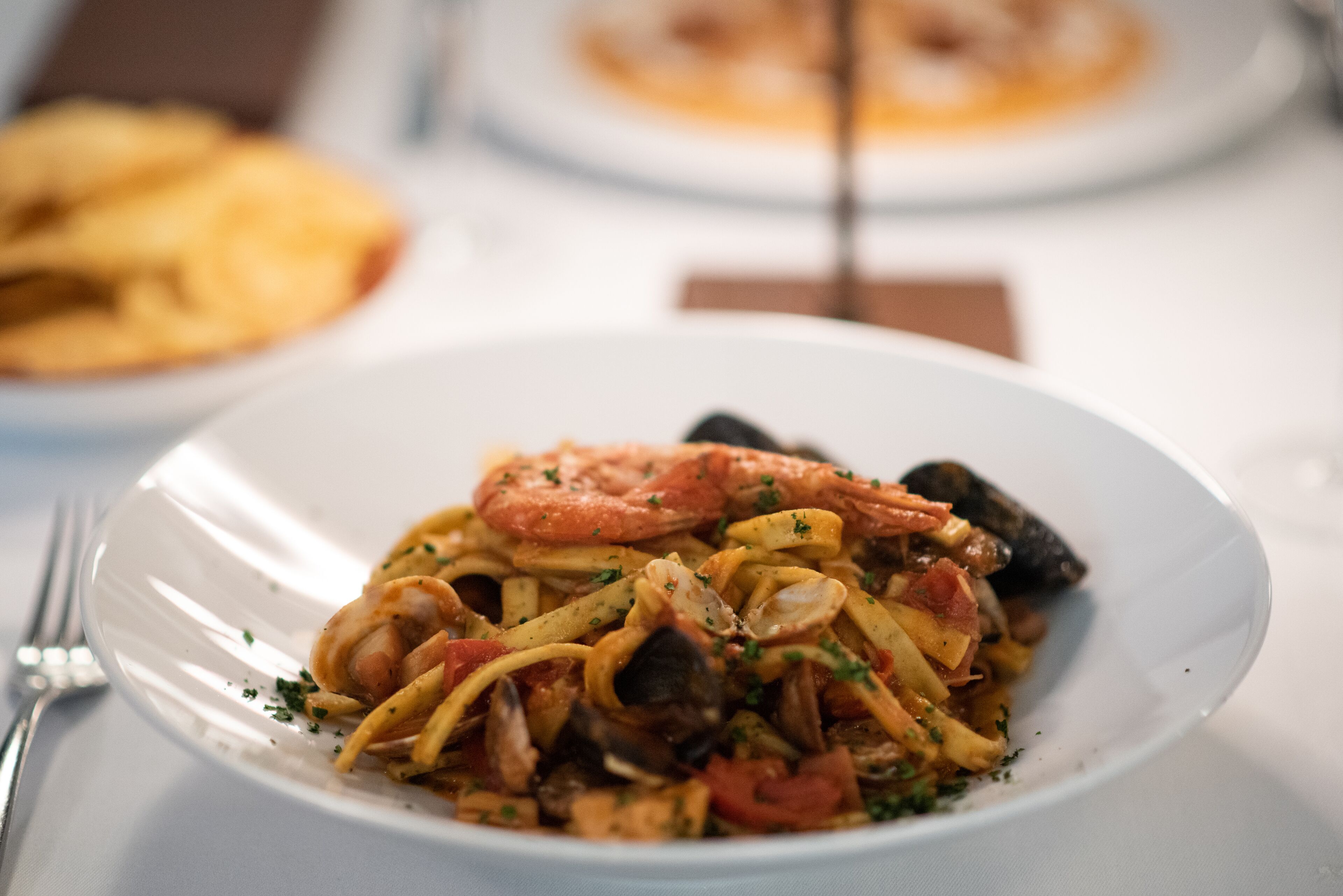 Un plato de pasta de mariscos con camarones y mejillones.