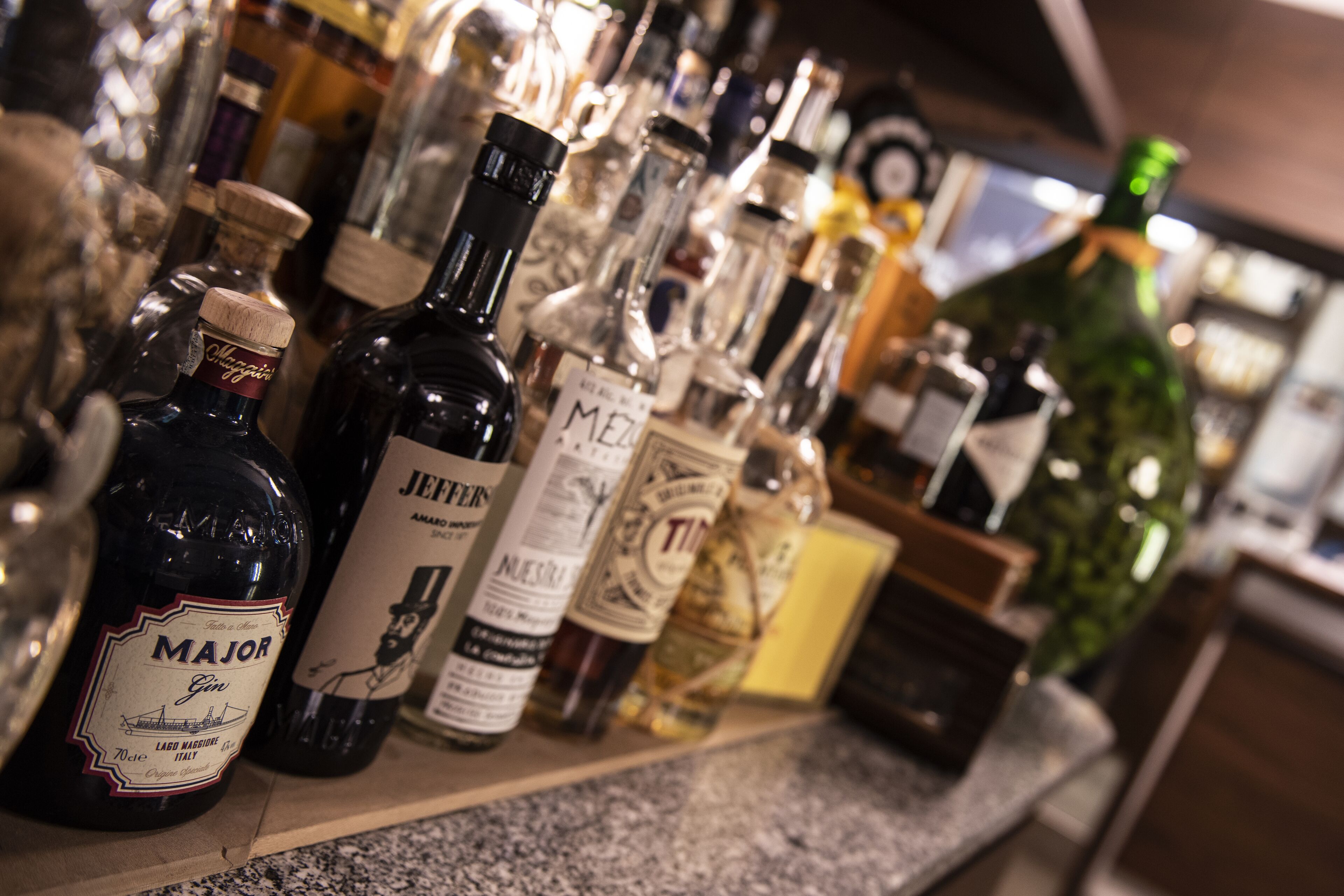 A variety of liquor bottles on a shelf.