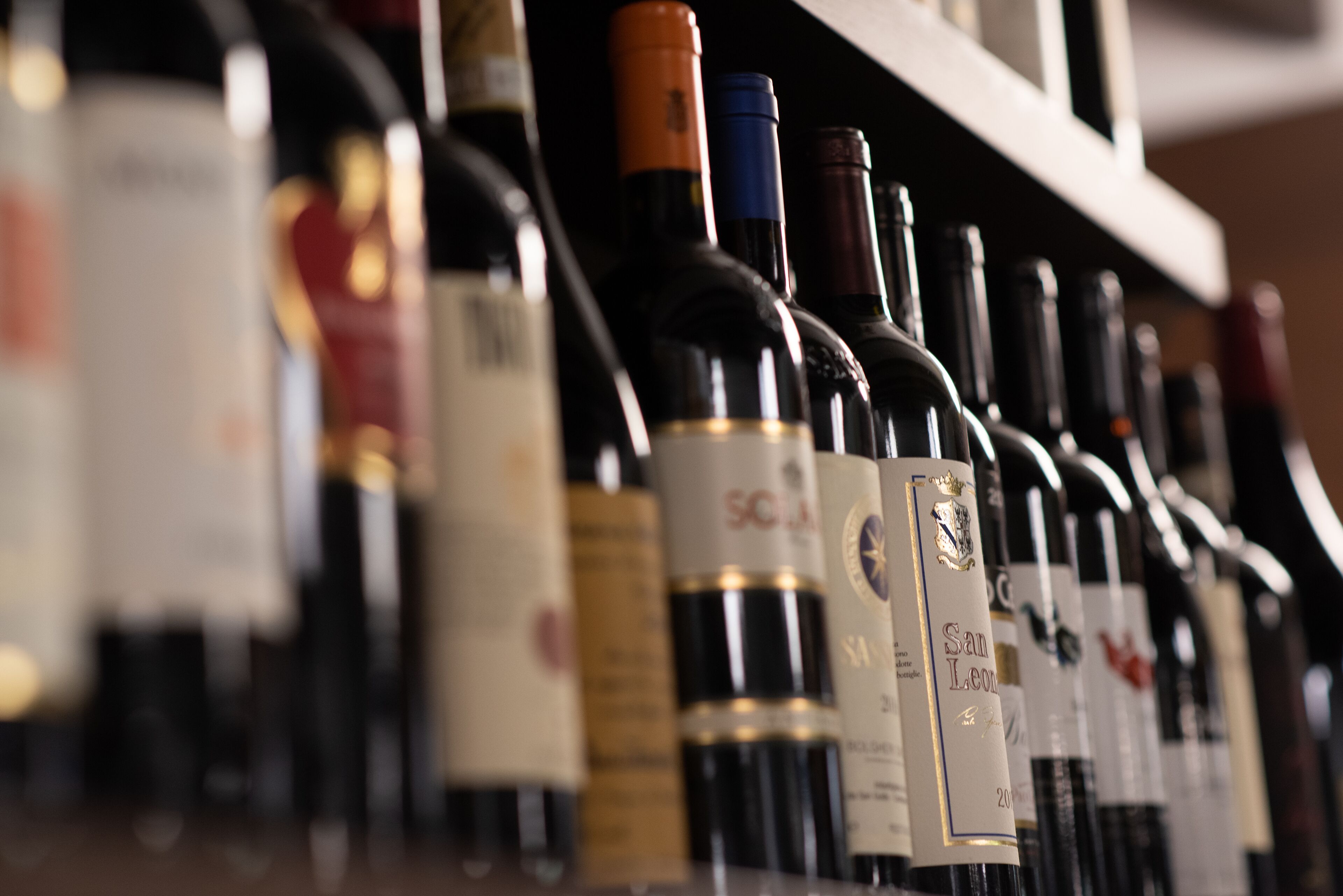 A row of wine bottles on a shelf.