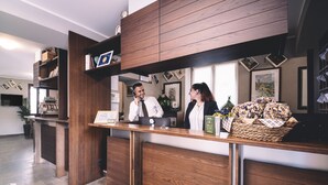 Ein Empfangsschalter mit Holzvertäfelung, eine Blumenkorb und gerahmte Bilder an der Wand.