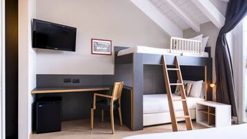 Une chambre moderne avec un lit superposé, un bureau, une chaise, un téléviseur et une petite poubelle.