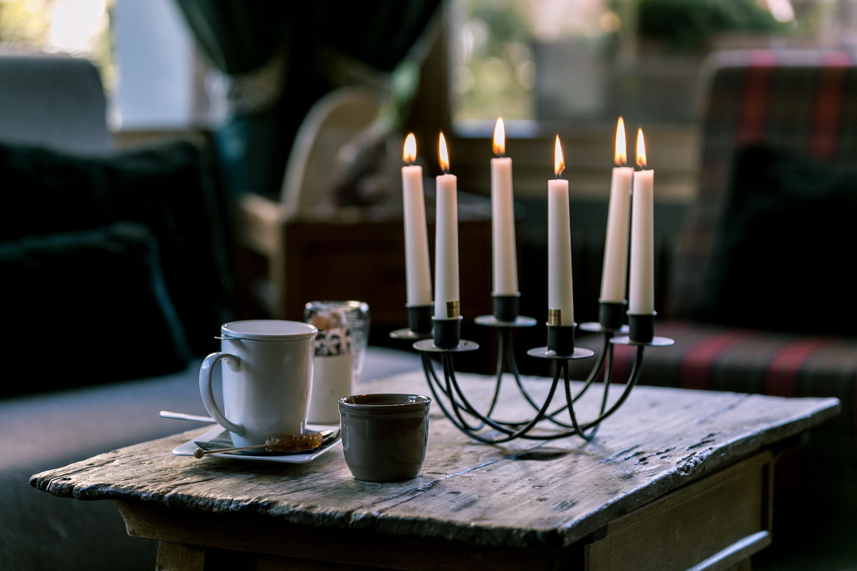 Ein Tisch mit Kerzenhalter, Tasse und kleiner Schale.
