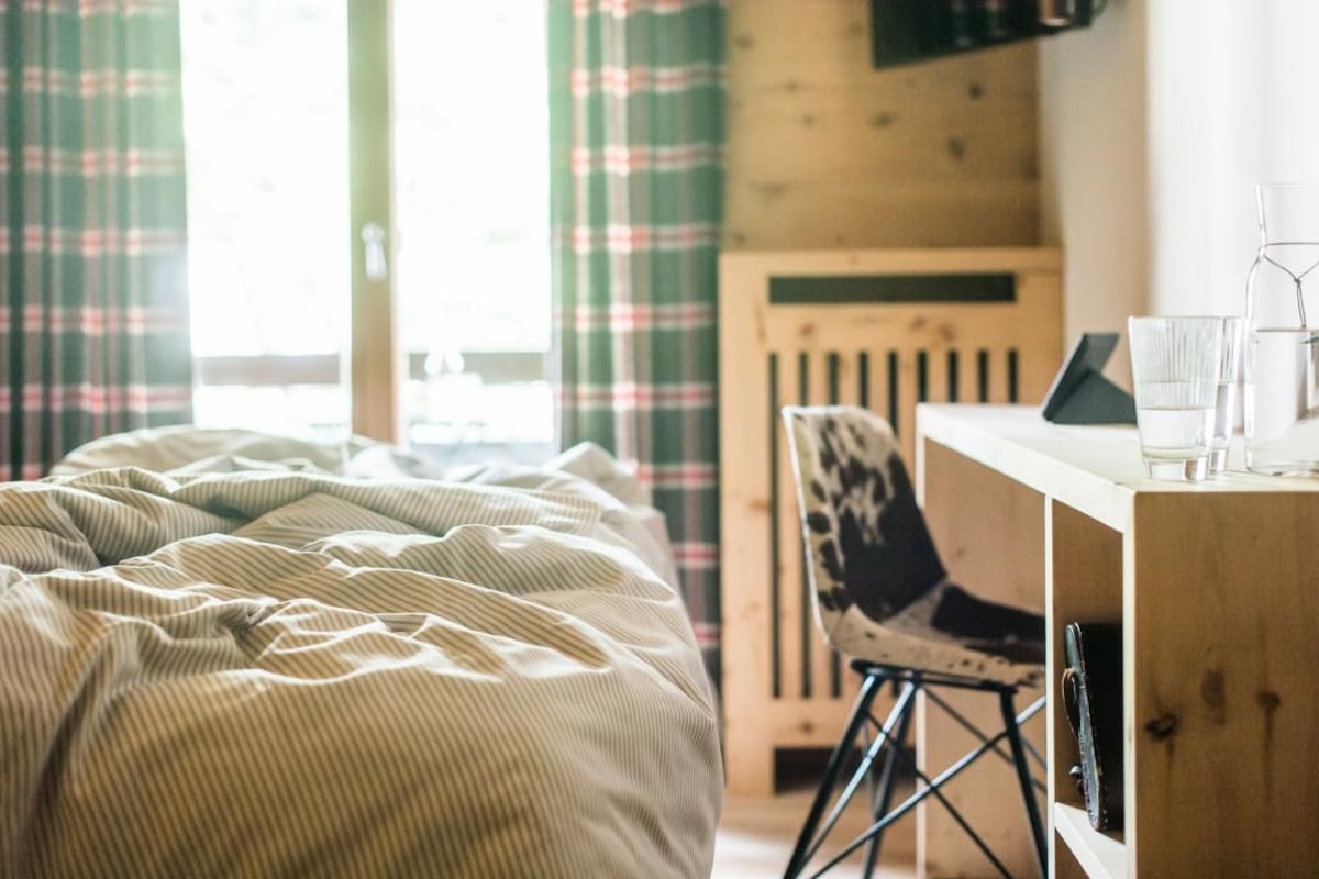 Um quarto aconchegante com uma cama, uma escrivaninha e uma cadeira.