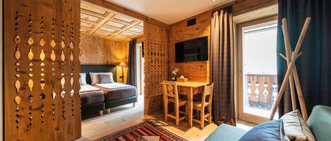Una habitación de cabaña de madera con una cama, un escritorio y un televisor.