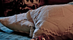 Una cama con una colcha y almohadas estampadas.