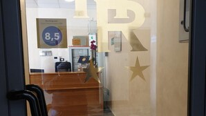 Un espace d’accueil d’hôtel doté d’un mur en verre sur lequel est affiché un grand logo « RH » et dont les clients ont attribué une note de 8,5 sur 10.