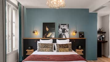 A modern bedroom with a large bed, two wall-mounted light fixtures, and a ceiling light.