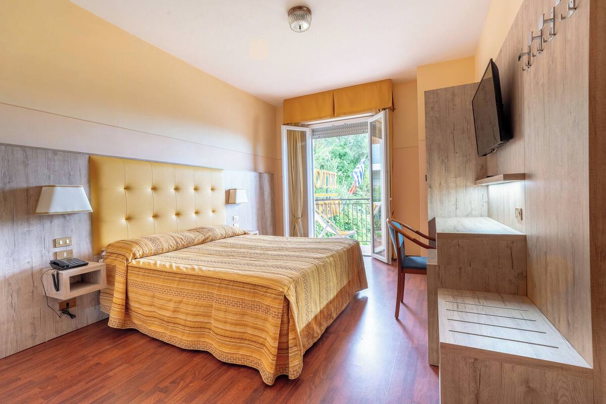 Une chambre d’hôtel moderne avec un grand lit, un bureau et une télévision.