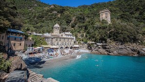 Un pueblo costero con un edificio histórico, una playa y un litoral rocoso.