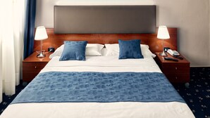 A hotel room with a bed, two bedside tables, a nightstand, a lamp, a phone, and a blue blanket. - Hotel Roberta (Mestre)