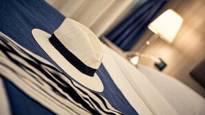 A hat on a bed with a striped blanket. - Hotel Roberta (Mestre)