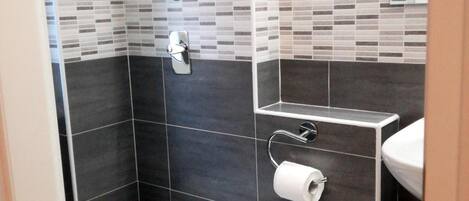 A modern bathroom with a toilet, bidet, and sink.