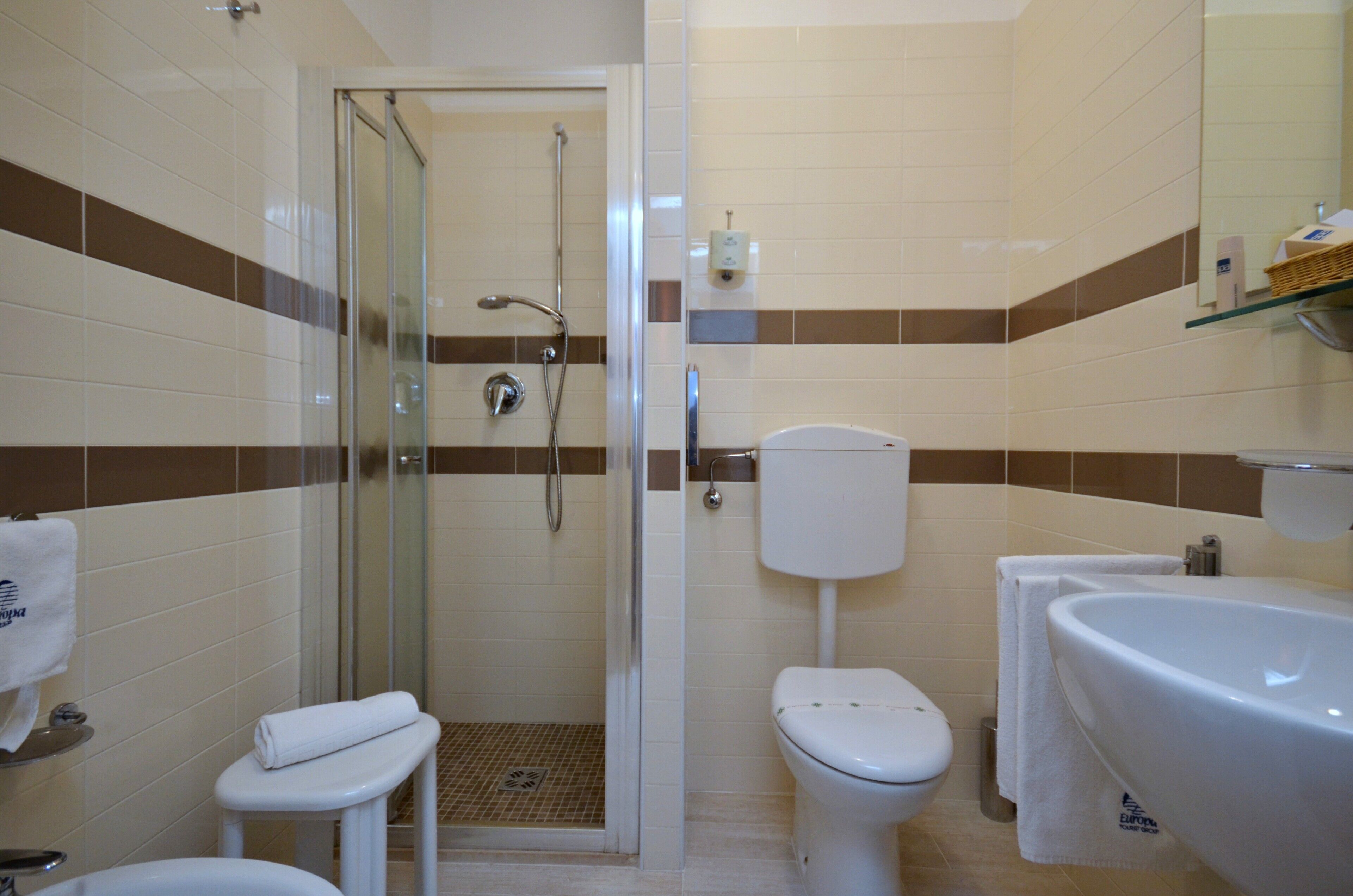 Un baño con ducha de vidrio, inodoro y lavamanos.