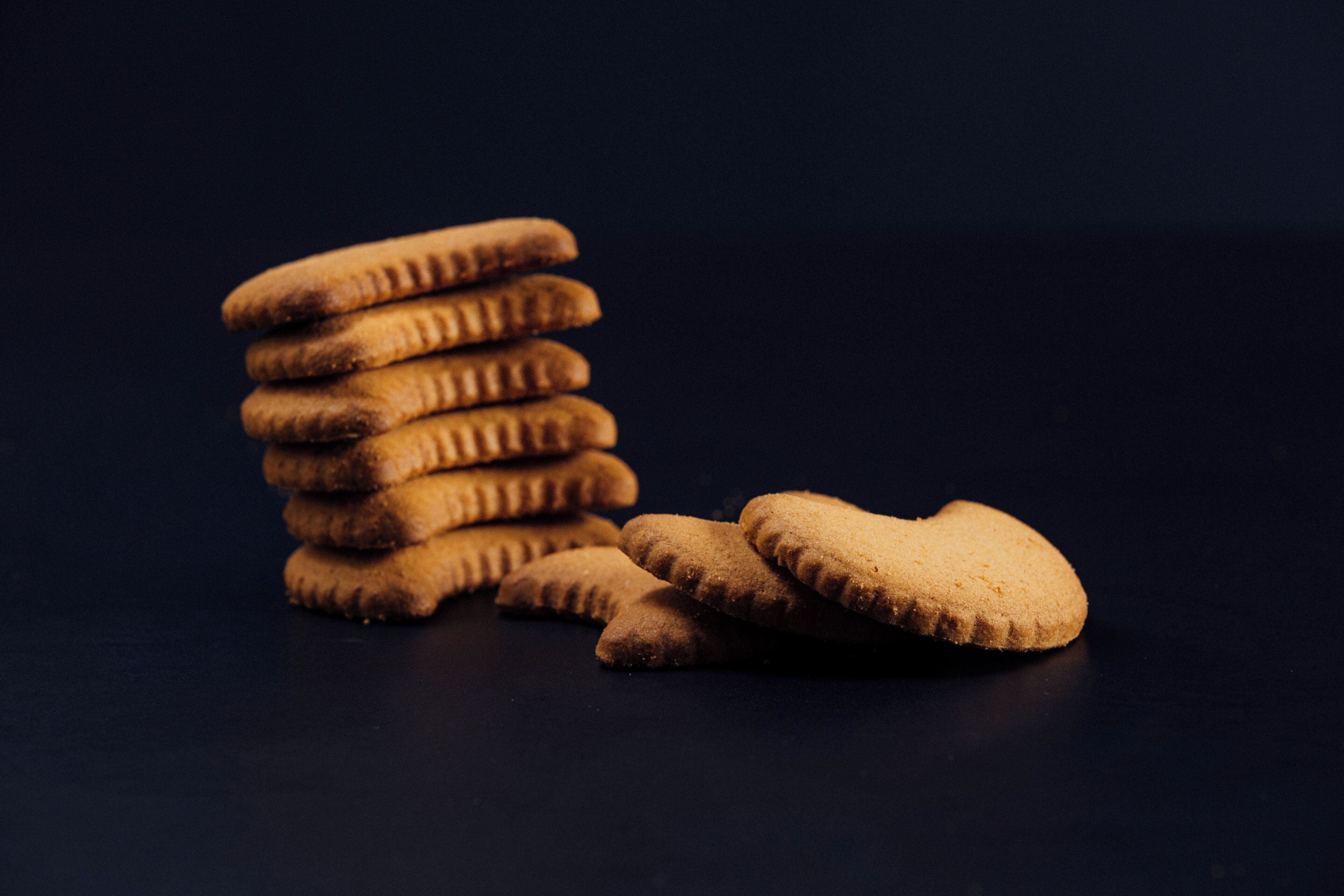 A stack of cookies on a dark surface.