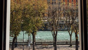 Une vue d’un bâtiment surmonté d’un dôme, avec des arbres et une rivière.