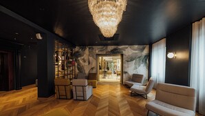 Un intérieur moderne avec un parquet en chevrons, un lustre et des meubles contemporains.