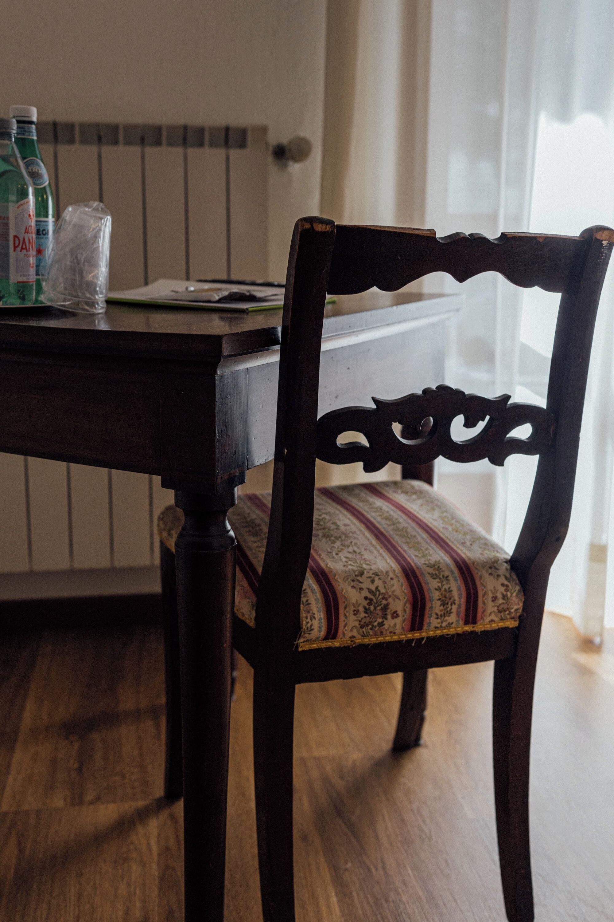 Una mesa de madera para comer con una silla que tiene un cojín estampado.