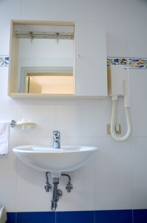 A bathroom with a white sink, a mirror, and a telephone. - Alloggi Barbaria (Venice)