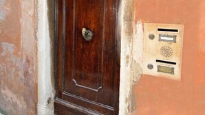 Una puerta de madera con manija de latón y un cartel encima.