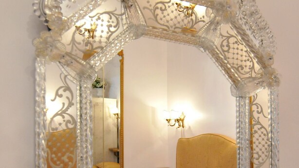 Un espejo con detalles ornamentales, similares al cristal.