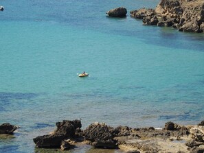 A clear view of a coastal area with rocky formations and calm turquoise waters. - Viticcio (Portoferraio)