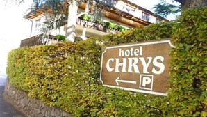 Een hotelschild voor 'hotel CHRYS' met een parkeersymbool.