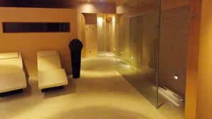 Een moderne spa-ruimte met een glazen wand, een receptiebalie en twee massagestoelen.