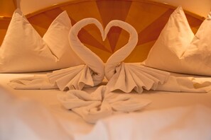 Una cama con toallas dispuestas en forma de corazón.